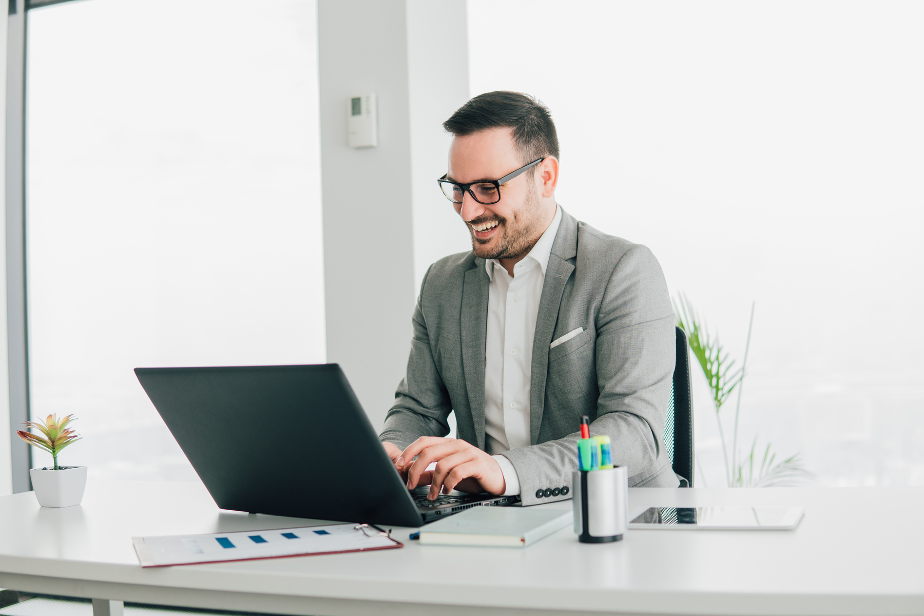 Happy businessman using laptop